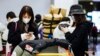 FILE - Travelers from Beijing, wearing masks, arrive at Charles de Gaulle airport in France, Jan. 27, 2020. Members of the East Asia community say the coronavirus, which originated in China, is giving rise to latent racism.