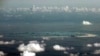 FILE - This aerial photo taken through a glass window of a military plane shows China's alleged on-going reclamation of Mischief Reef in the Spratly Islands in the South China Sea, May 11, 2015. 