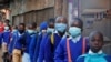 Schoolchildren queue to have their temperature checked before entering the Olympic Primary School during the reopening of schools, after the government closed learning institutions due COVID-19 outbreak, in Kibera slums of Nairobi, Jan. 4, 2021.