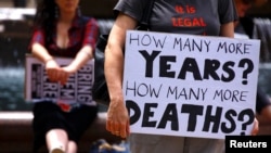 FILE - Refugee advocates participate in a protest in Sydney against the treatment of asylum-seekers at Australia-run detention centers, Nov. 18, 2017. 