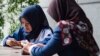 Dua remaja putri menggunakan ponselnya untuk mengakses internet di sebuah cafe di Jakarta (foto: ilustrasi). 
