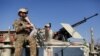 FILE - Afghan security forces inspect the site of an attack in a U.S. military air base in Bagram, north of Kabul, Afghanistan, Dec. 11, 2019.