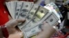 A worker counts U.S. dollar bills, which are being exchanged for Philippine Pesos, inside a money changer in Manila, April 1, 2013. 