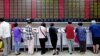 Investors look at computer screens showing stock information at a brokerage house in Shanghai, China, July 8, 2015.