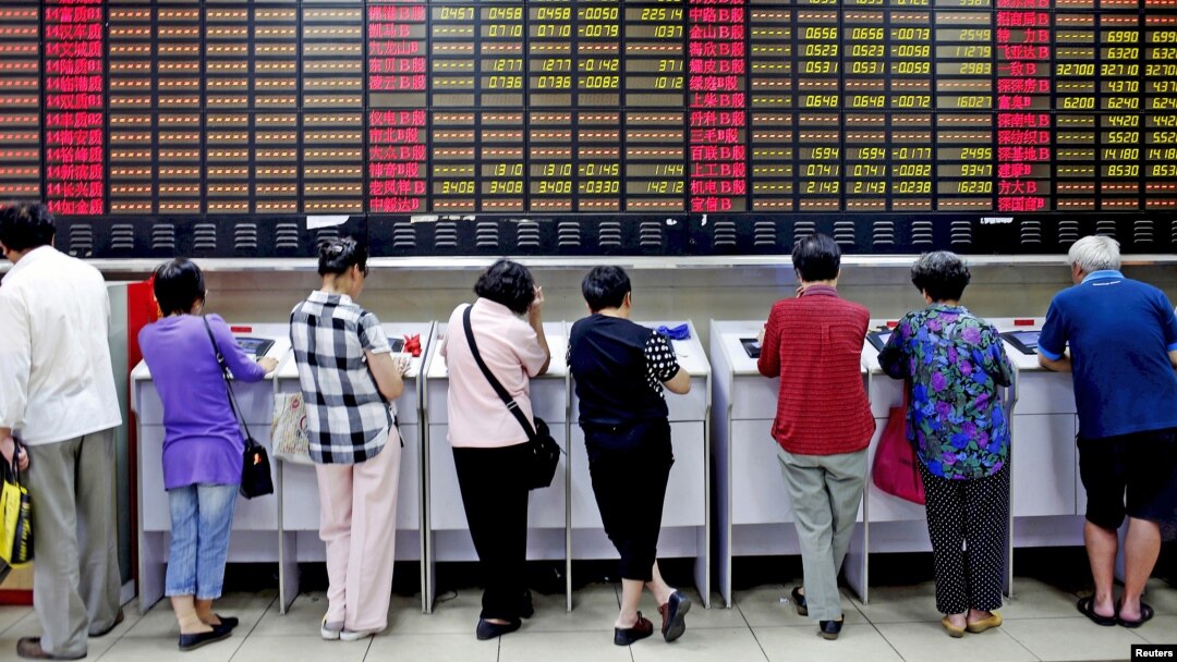 Investors look at computer screens showing stock information at a brokerage house in Shanghai, China.