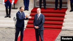 Former French Prime Minister Edouard Philippe applauds newly appointed Prime Minister Jean Castex in the courtyard of the Matignon Hotel during the handover ceremony in Paris, France, July 3, 2020. 