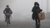 People ride amid the smog in Beijing, China, Feb. 14, 2017. 