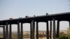 Traffic moves along a bridge as seen from a train in New Jersey, May 18, 2021.