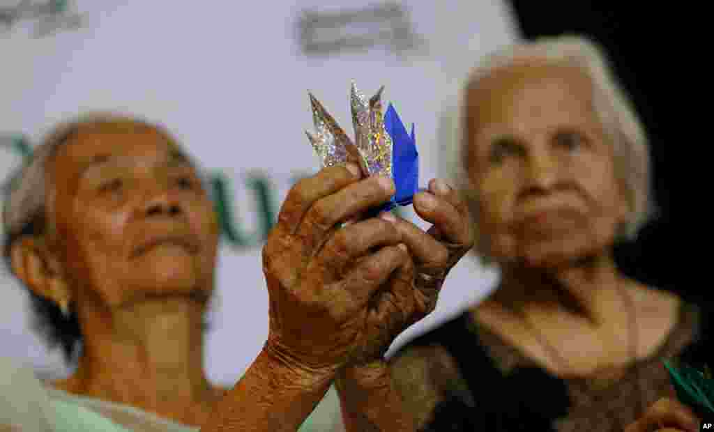 Alleged Filipino &quot;comfort women&quot; Narcisa Claveria, 85, left, and Hilaria Bustamante, 90, display Origami paper cranes to symbolize peace during a forum in Quezon city, northeast of Manila, Philippines. The forum was held to demand justice, compensation and apology from the Japanese government for their alleged WWII ordeal.&nbsp;