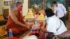 រូប​ឯកសារ៖ ស្រ្តី​ម្នាក់​កំពុង​ប្រគេន​ទេយ្យទាន​ដល់​ព្រះ​សង្ឃ​​ក្នុង​វត្ត​និរោធ​រង្សី រាជធានី​ភ្នំពេញ ក្នុង​អំឡុង​​ពេល​​ប្រារព្ធ​ពិធី​បុណ្យ​ចូល​ឆ្នាំ​ខ្មែរ​ថ្ងៃទី​២ នៅ​ថ្ងៃ​ទី​១៤ ខែមេសា ឆ្នាំ​២០២០។ (កាន់ វិច្ឆិកា/VOA)​​