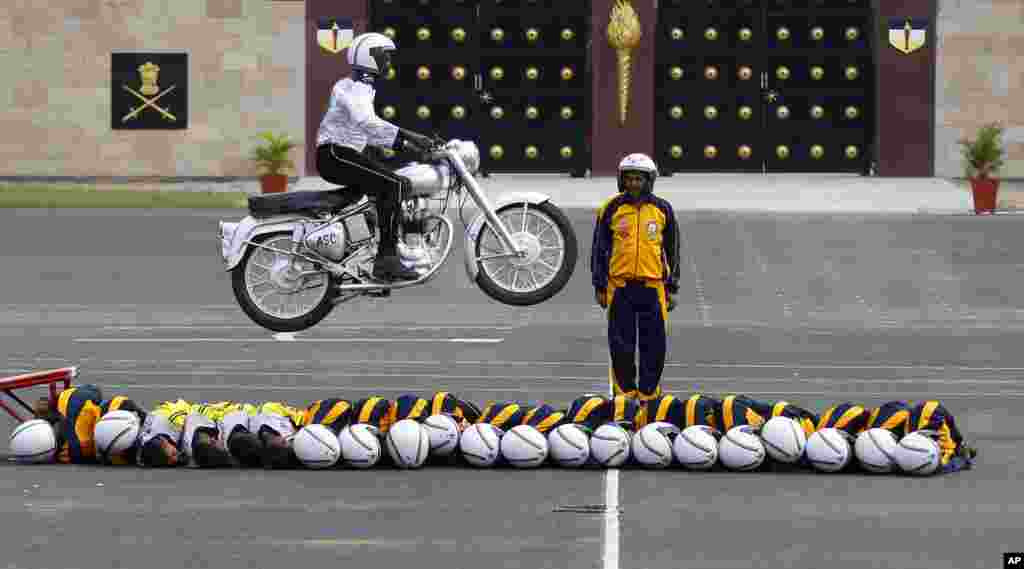 Members of ASC Tornados, the motorcycle display team of the Indian army, lie in a row on the ground as another performs a stunt during the 225th anniversary celebrations of Army Service Corps in Bangalore.