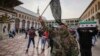 A masked fighter carries a flag of the Hayat Tahrir al-Sham group as others hold flags of the Syrian opposition, in the courtyard of the Umayyad Mosque in the old walled city of Damascus, Syria, Dec. 10, 2024.