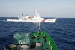 FILE - A ship (top) of the Chinese Coast Guard is seen near a ship of the Vietnam Marine Guard in the South China Sea, about 210 km (130 miles) off shore of Vietnam, May 14, 2014