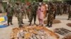 FILE - Military officials stand near ammunitions seized from suspected members of Hezbollah after a raid of a building in Nigeria's northern city of Kano, May 30, 2013.