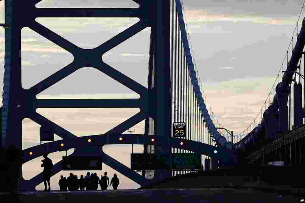 A family from Trenton, New Jersey, walks over the Benjamin Franklin Bridge ahead of a Sunday Mass to be delivered by Pope Francis in Philadelphia, Pensylvania, before flying back to Rome.