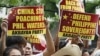 Protesters display placards during their rally outside the Chinese Consulate at the financial district of Makati city, east of Manila, Philippines, April 16, 2012.