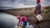 FILE: Martha Kasafi (right) and her daughter, both refugees from Democratic Republic of Congo, collect water for their vegetable crops at a water pan in Kalobeyei settlement for refugees in Turkana County, Kenya on Oct. 2, 2019.