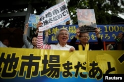 Tai Yamaguchi, 75, who has been tending her family's fish shop for more than 50 years in Tsukiji market, takes part in a rally denouncing market's relocation plan outside the Tsukiji market in Tokyo, Japan, Sept. 29, 2018.