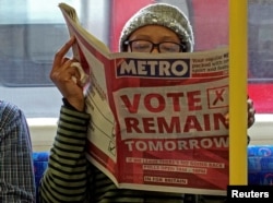 FILE - A woman reads a newspaper on the underground in London with a 'vote remain' advert for the BREXIT referendum, Britain, June 22, 2016.