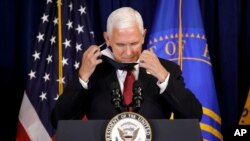 Le vice-président Pence enlève son masque facial alors qu'il arrive au podium pour parler à Rockville, au Maryland, le 30 juin 2020. (AP)