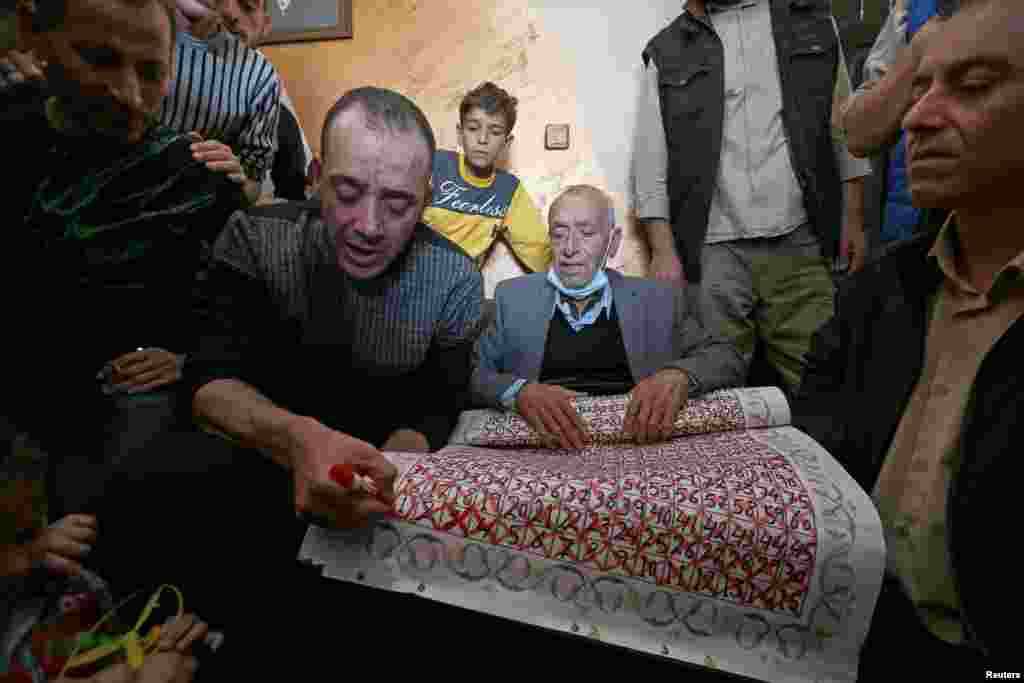 Freed Palestinian prisoner Abdel-Raouf Qe&#39;dan, who served a 16-year sentence in an Israeli jail, marks the last day on a calendar made by his father, who was counting down the days until his son&#39;s release, in Rafah in the southern Gaza Strip.