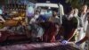 Volunteers and medical staff bring an injured man for treatment after two powerful explosions outside the airport in Kabul on Aug. 26, 2021.