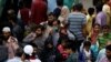 A man wears a protective mask as a preventive measure against coronavirus, while walks with others to board a train at the Cantonment railway station in Karachi, Pakistan, March 15, 2020. 