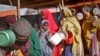 FILE - Newly-arrived women who fled drought queue to receive food distributed by local volunteers at a camp for displaced persons in the Daynile neighborhood on the outskirts of the capital Mogadishu, in Somalia, May 18, 2019.