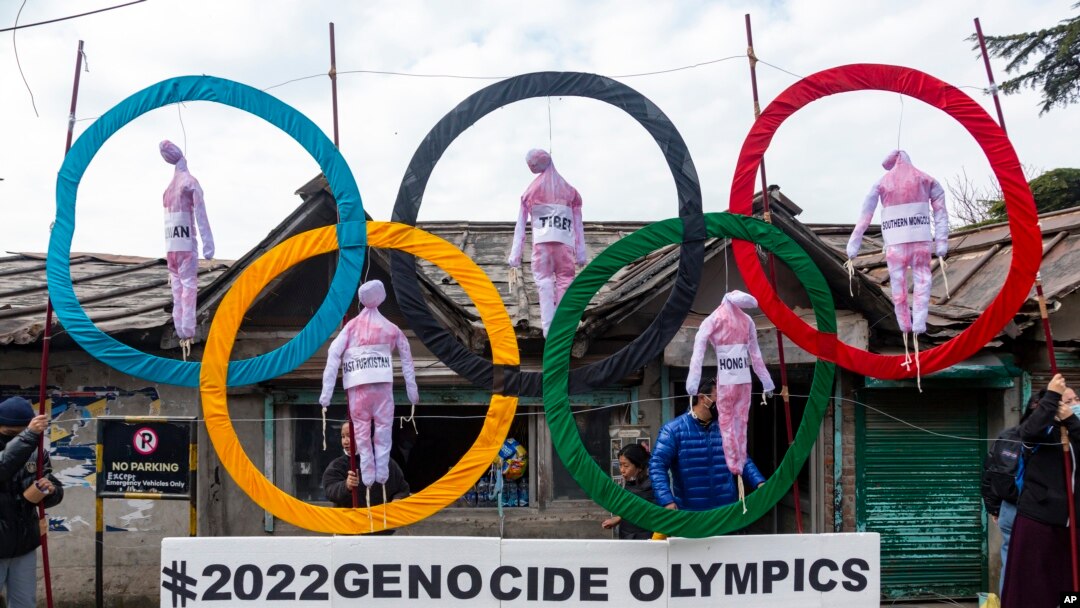 FILE - Exile Tibetans use the Olympic Rings as a prop as they hold a street protest against the holding of 2022 Winter Olympics in Beijing in Dharmsala, India, Feb. 3, 2021. 