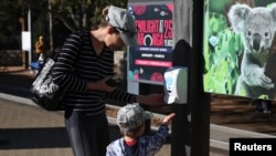 Visitors stop at a hand sanitiser station while making their way into Taronga Zoo Sydney as it re-opens to the public amidst the easing of the coronavirus disease (COVID-19) restrictions following an extended closure in Sydney, Australia, June 1, 2020. REUTERS/Loren Elliott