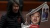 Lawmaker Leung Kwok-hung, demanding better welfare for the elderly, carries a mocking portrait of Hong Kong Financial Secretary John Tsang before Tsang's annual budget report at the Legislative Council in Hong Kong, Feb. 24, 2016.