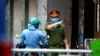 A police officer talks to a woman at the barricaded entrance of an alley where one of its residents is suspected to have COVID-19 in Hanoi, Vietnam, July 29, 2020.