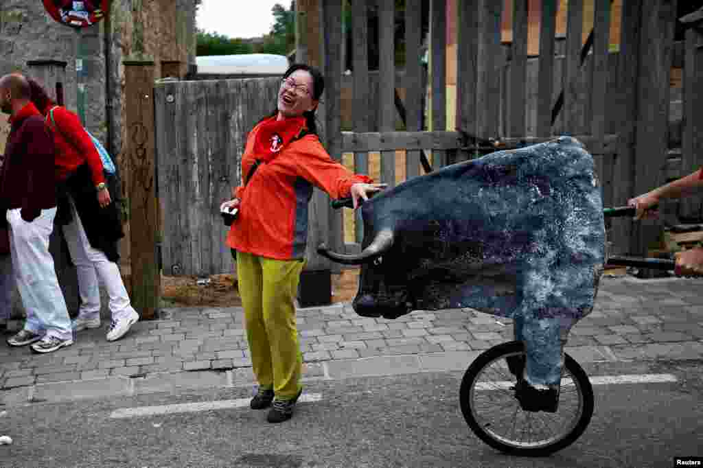 Seorang turis perempuan terkejut &#39;diseruduk&#39; boneka banteng di lokasi festival &#39;Lari Dikejar Banteng&#39; di Pamplona, Spanyol.