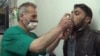 FILE - This video image from an anti-Bashar Assad activist group shows a Syrian man being treated with an inhaler in Kfar Zeita, north of Damascus, after what witnesses said was a chlorine gas attack, April 18, 2014.