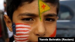 Zarokekî Kurd rûyê xwe bi alên Amerîka, YPG û Kurdistanê reng kiriye