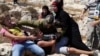 FILE - In this Aug, 28, 2015 photo, Palestinian women and girls scuffle with an Israeli soldier trying to arrest a 12-year-old boy during a protest near the West Bank village of Nebi Saleh.