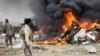 FILE - Shi'ite fighters known as Hashid Shaabi look at smoke from an explosives-laden military vehicle driven by an Islamic State suicide bomber that exploded during an attack on the southern edge of Tikrit.