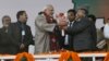 Indian Prime Minister Narendra Modi, center, is given flowers as he arrives for a campaign rally ahead of local elections in Srinagar, in Indian-controlled Kashmir, Dec. 8, 2014. 