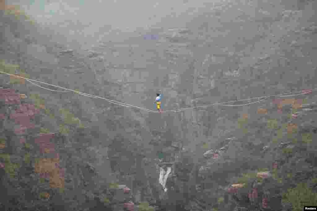 Pria Perancis, Theo Sanson, berjalan di atas kabel di antara pegunungan dalam lomba di Jiaozuo, Henan, China.
