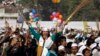 A supporter of Aam Aadmi (Common Man) Party (AAP) cheers after its leader Arvind Kejriwal took an oath as the new chief minister of Delhi during a swearing-in ceremony at Ramlila ground in New Delhi, Dec. 28, 2013. 