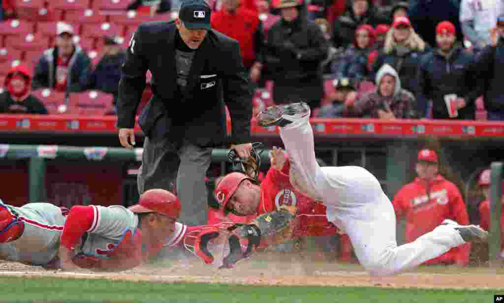 Cincinnati Reds&#39; Tucker Barnhart scores on a double by Reds&#39; Scott Schebler, as Philadelphia Phillies catcher Carlos Ruiz attempts the tag during the third inning of a baseball game, in Cincinnati, Ohio.