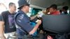 Malaysian police personnel checks identity of passengers on a road leading to Kampung Tanduo, where Malaysian troops stormed the camp of an armed Filipino group, in Lahad Datu, Sabah state, Mar. 8, 2013 