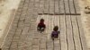 FILE - Indian children work at a brick factory on the outskirts of Jammu, India, May 1, 2018. 