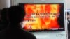 People watch a television program showing a propaganda video released by North Korea at Seoul Railway Station in Seoul, South Korea, February 20, 2013. 