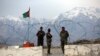 FILE - Afghan National Army soldiers stand guard at a checkpoint near the Bagram base in northern Kabul, Afghanistan, April 8, 2020.