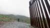 FILE - A Border Patrol agent looks on near where a border wall ends that separates the cities of Tijuana, Mexico, and San Diego, California, Feb. 5, 2019, in San Diego. 