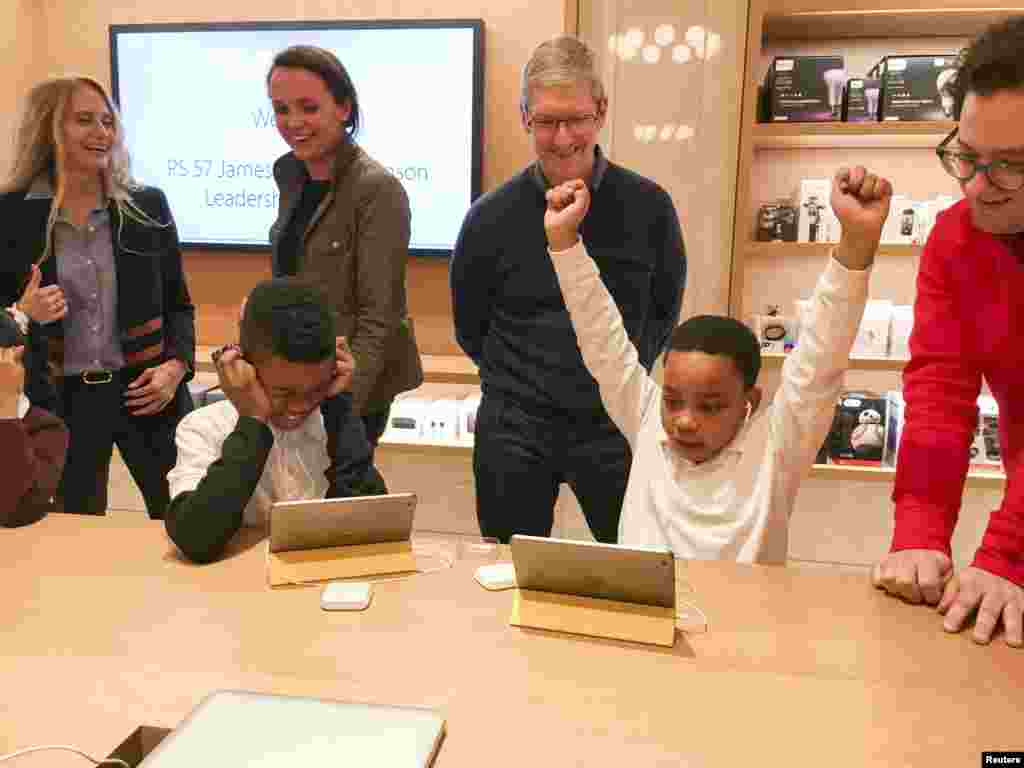 Apple Chief Executive Officer Tim Cook (C) attends an event for students to learn to write computer code at the Apple store in the Manhattan borough of New York, Dec. 9, 2015.