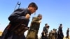 FILE - Kurdish Peshmerga security forces stand guard on the outskirts of the northern city of Mosul, Iraq.