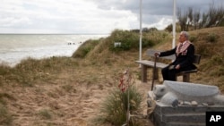World War II D-Day veteran and Penobscot Elder from Maine, Charles Norman Shay sits on a bench next to his memorial stone at Omaha Beach prior to a ceremony in Saint-Laurent-sur-Mer, Normandy, France, Friday June 5, 2020.