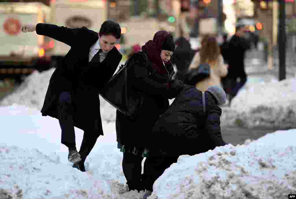 People try to navigate a snowbank in the middle of Park Avenue as New Yorkers return to work after the city was hit with a record-setting snowfall.